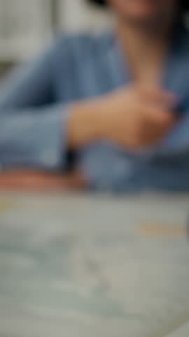 A person is extending a passport while holding travel documents at an airport. The background shows a bustling airport environment with travelers in motion, indicating a busy day of travel
