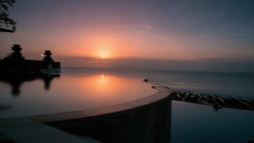 Timelapse of a panoramic vista of a infinity pool at sunset over a calm ocean, featuring a serene color palette - Powered by Shutterstock - Get 15% off with code: PIKWIZARD15