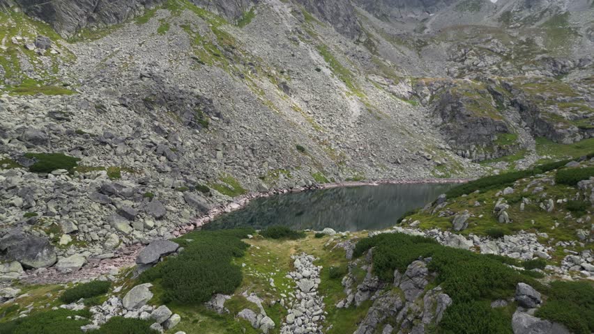 A small lake between rocks and mountains
