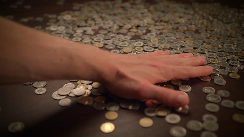 Coins on a table symbolize different aspects of economics, including abundance and wealth