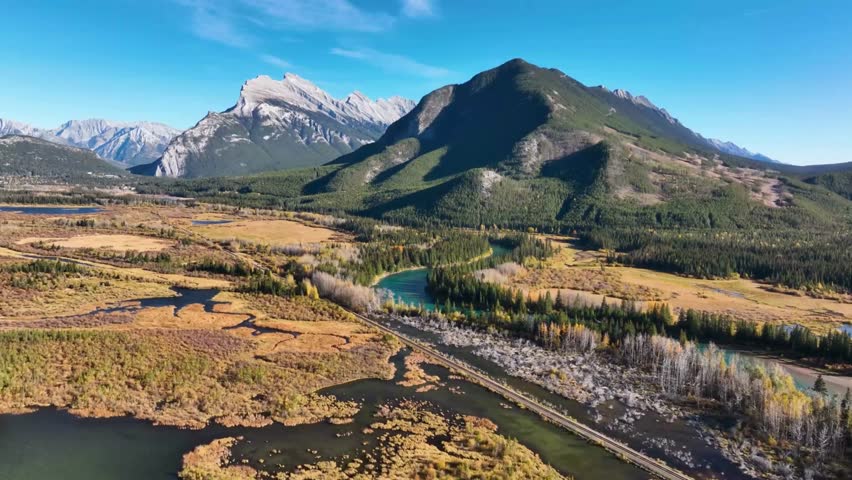 A breathtaking aerial view of the Bow Valley in Banff National Park, Alberta, Canada. The majestic peaks of Mount Rundle and Cascade Mountain rise majestically above the valley, with the Bow River