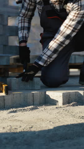 Paver Installer Working Near a Cottage Construction Site