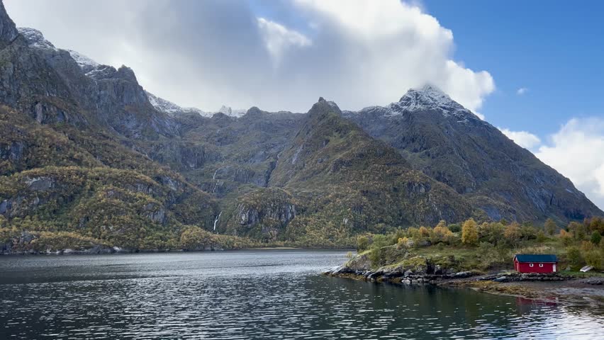 Water reflects mountains and a cloudy sky in norway