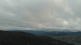 Aerial View Of Majestic Mountains And Lush Forest Under Dark Clouds. A Stunning Rainbow Appears After The Rain As The Drone Soars Through Misty Clouds, Revealing A Breathtaking Scene. - Powered by Shutterstock - Get 15% off with code: PIKWIZARD15