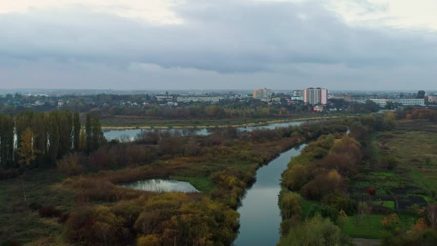 Two rivers converge into one near a large city. View from above. Panorama of the city, landscape. Moving the camera forward
