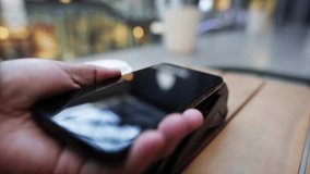 Contactless payment process involving customer using smartphone for wireless transaction at coffee shop point of sale terminal. Showcasing modern digital payment technology and financial convenience - Powered by Shutterstock - Get 15% off with code: PIKWIZARD15
