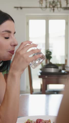Girl Drinks Water From Glass Sitting At Home In Kitchen After Lunch