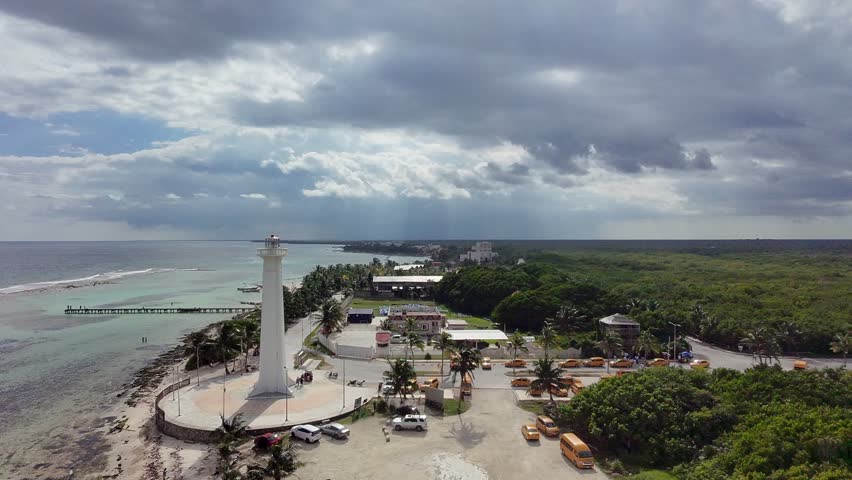 Lighthouse in Mahahual Mexico a long the shore of the caribbean sea at the cruise port of Costa Maya Mexico with downtown and the forest in the distance a peir going into the ocean with taxi parking