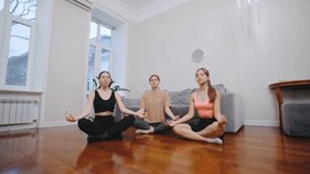 Three women practicing mindfulness meditation in a cozy living room during a calm afternoon - Powered by Shutterstock - Get 15% off with code: PIKWIZARD15