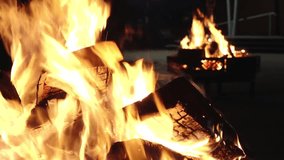 A burning bonfire with glowing logs at night, surrounded by people in warm clothing during a solemn gathering. The scene captures a sense of community and reflection. - Powered by Shutterstock - Get 15% off with code: PIKWIZARD15