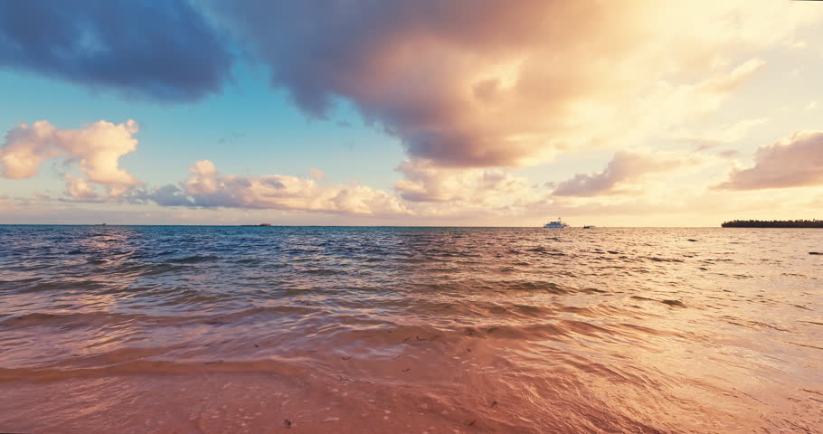 Sunrise over ocean costal shore and tropical island beach with color cloudscape