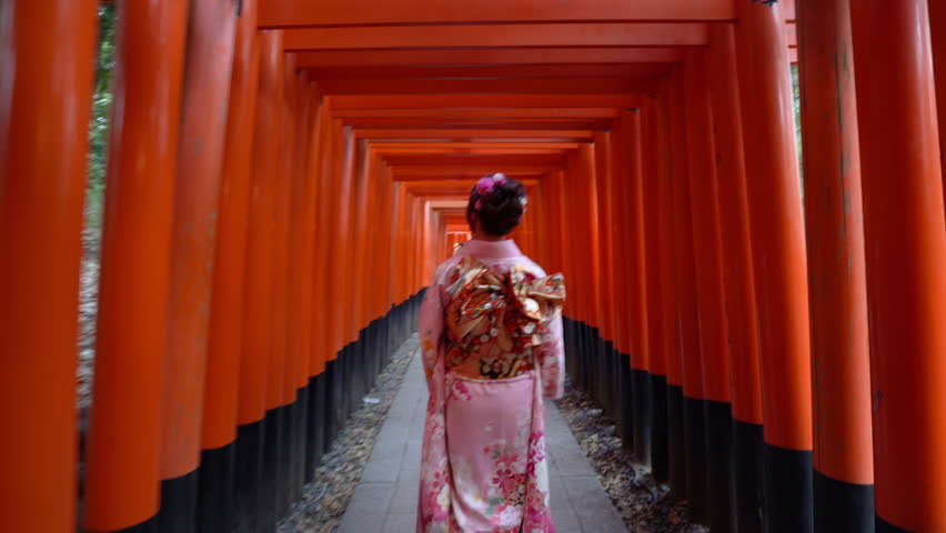Japanese women in a traditional Japanese kimono walks at Fushimi Inari Shrine in Kyoto. landmarks of Japan	