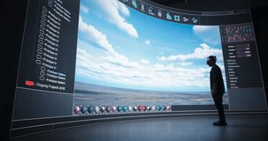 Young Architect Using Virtual Reality Technology, Dynamically Constructs a Digital Cityscape on a Massive Screen in a Dark Studio. Creative Man Wearing a VR Headset and Holding Motion Controllers - Powered by Shutterstock - Get 15% off with code: PIKWIZARD15