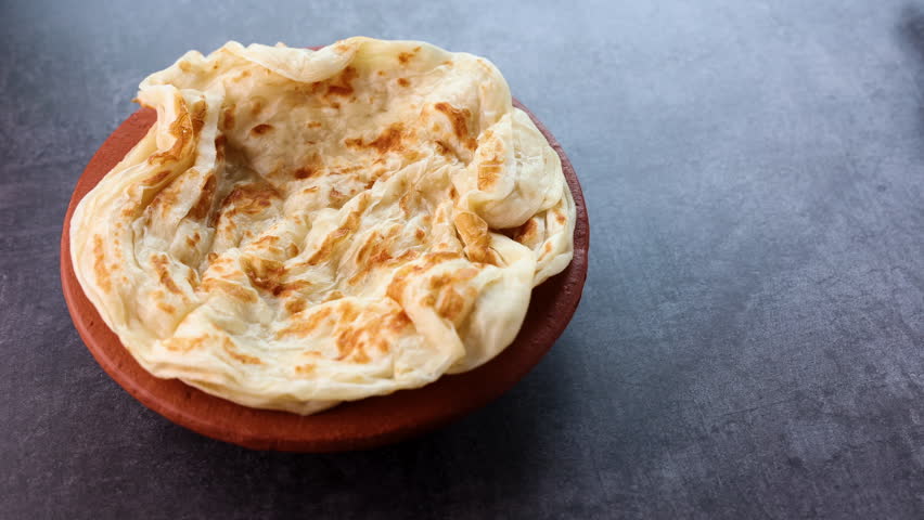 Fish curry with Kerala parathas porotta roti parotta barotta naan layered flatbread made from maida whole wheat flour. Eat with spicy Asian chicken beef egg curry gravy. Indian food