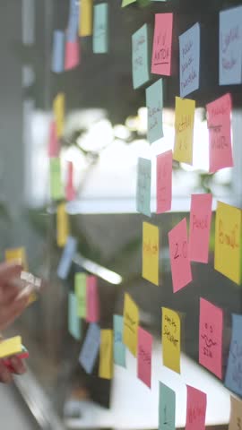 Young Business Team Brainstorming. Business Woman Draws a Graph On Glass Wall With Stickers. Colleagues Approve. Business Success Concept