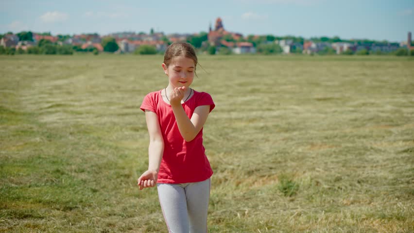 Teenage girl dancing energetically outdoors to rhythm of modern youth music. Young female moving with energy in sync with contemporary beats outside. Girl dancing lively to trendy music in open air