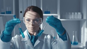 In a laboratory, a skilled scientist analyzes chemical solutions in test tubes, providing insights that advance scientific knowledge and enhance understanding of complex concepts and processes - Powered by Shutterstock - Get 15% off with code: PIKWIZARD15