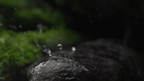 Water droplets falling on a rock surface close up. Aqua drops falls and splashing on a stone. Concept of natural springs and wellness or beauty products. Cold mineral water in super slow motion - Powered by Shutterstock - Get 15% off with code: PIKWIZARD15
