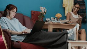 Two cheerful female students searching information on internet using laptop and smartphone while completing homework assignment in dorm room - Powered by Shutterstock - Get 15% off with code: PIKWIZARD15