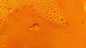 Orange paint and floating oil bubbles macro. Abstract top down background or design element. - Powered by Shutterstock - Get 15% off with code: PIKWIZARD15
