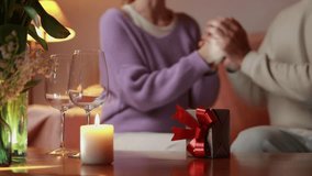 Romantic couple sharing intimate moment, exchanging meaningful gift by candlelight, symbolizing deep emotional bond.International women's day - Powered by Shutterstock - Get 15% off with code: PIKWIZARD15