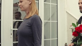 Loving mature couple embracing, holding red roses, sharing intimate connection during valentine's day moment near home entrance.Celebrating valentine's day or anniversary - Powered by Shutterstock - Get 15% off with code: PIKWIZARD15