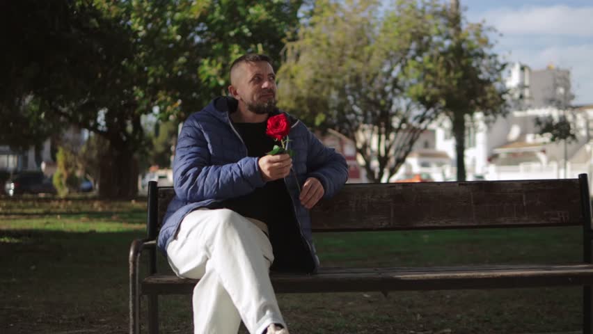 Loving couple sharing intimate moment, man presenting vibrant red rose, woman receiving bloom with gentle smile, displaying tender emotional connection.Celebrating valentine
