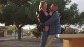 Affectionate couple embracing, sharing red rose amid lush park greenery, expressing deep romantic connection under warm sunlight.Celebrating valentine's day or anniversary - Powered by Shutterstock - Get 15% off with code: PIKWIZARD15