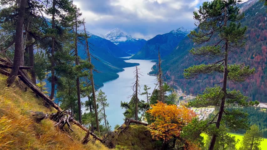  Plansee lake among snow-capped mountains in Tyrolean Alps, Austria late autumn in cloudy weather. High quality 4k footage
