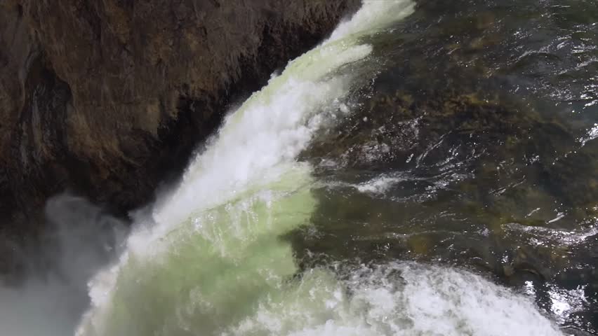 Rainbow over the waterfall. Amazing mountain landscape. Big waterfall among the beautiful rocks. Brink of the Lower Falls on the Grand Canyon of the Yellowstone, Yellowstone National Park, Wyoming.