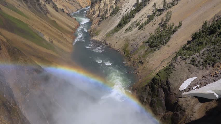 Rainbow over the waterfall. Amazing mountain landscape. Big waterfall among the beautiful rocks. Brink of the Lower Falls on the Grand Canyon of the Yellowstone, Yellowstone National Park, Wyoming.