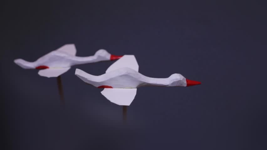 flight of white swans in the dark sky, sculptural composition