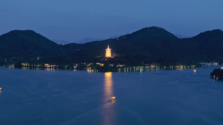 Aerial shot of tower and beautiful West Lake at night in Hangzhou, China