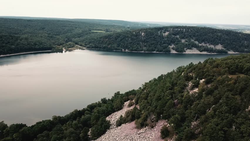 A serene aerial view of Devils Lake surrounded by lush forests and rocky cliffs in Wisconsin