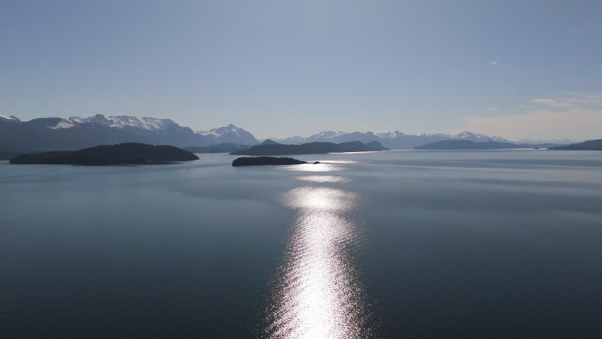 Drone flight over Lake Nahuel Huapi with snow peaked mountains in ditsance