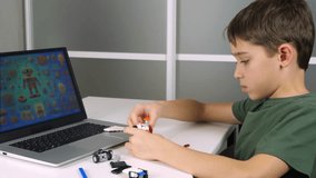 AI assistant kids helps child assemble construction set. Child builds model with AI assistant while looking at monitor screen. Artificial intelligence guides child on how assemble construction set. - Powered by Shutterstock - Get 15% off with code: PIKWIZARD15