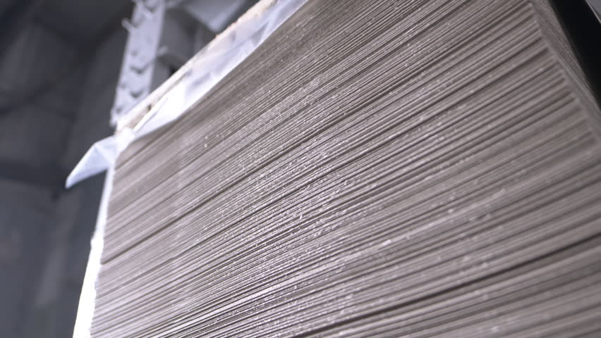 Spacious factory warehouse with stack of cardboard sheets. Zone allows for convenient packaging and transportation of material within hall