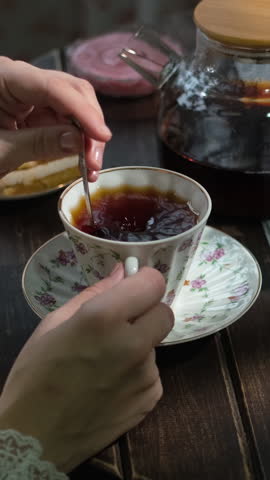 Vertical video. Tea party, morning breakfast. Woman drinking tea with sugar and fresh pastries.
