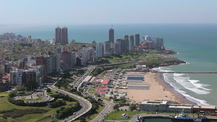 Panning aerial movement above the Mar del Plata city tall buildings and sandy beaches, Argentina.
