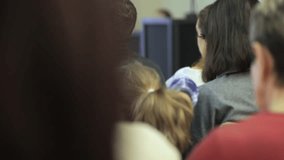 A group of people are sitting in a room, with one woman wearing a purple shirt. Scene is casual and relaxed, as the people are gathered together in a comfortable setting - Powered by Shutterstock - Get 15% off with code: PIKWIZARD15