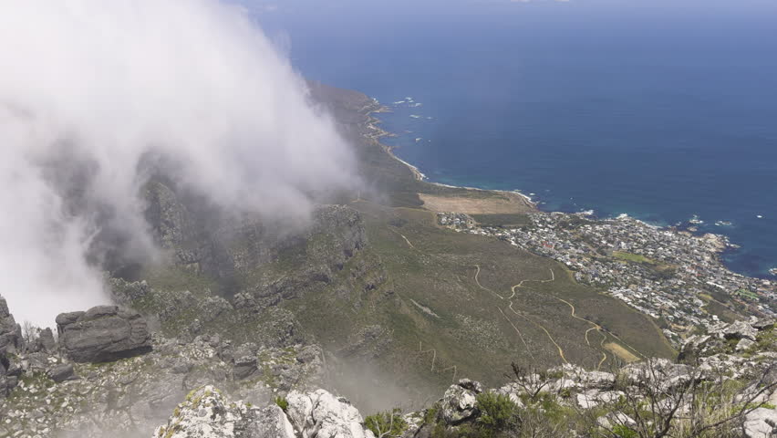 Breathtaking view from Table Mountain, Cape Town, with clouds rolling over the coastline