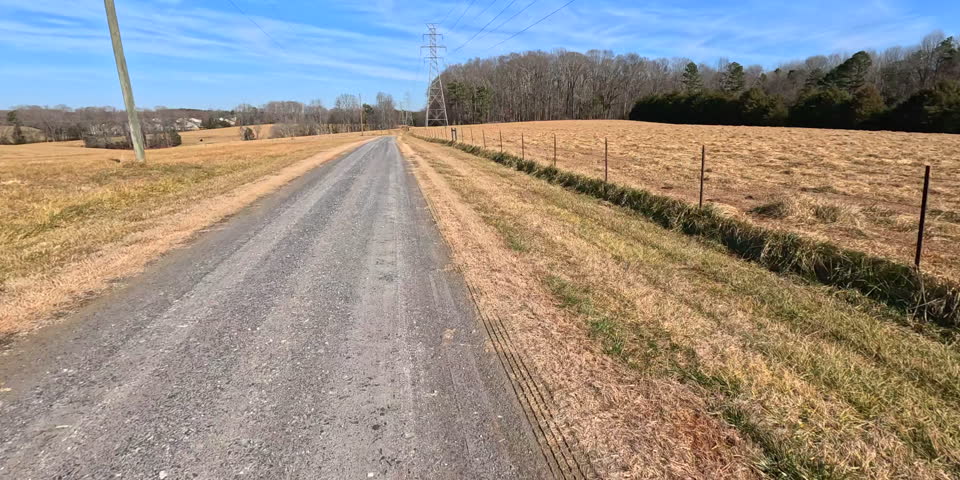 Gravel Road Driving Passing Pasture And Fencing