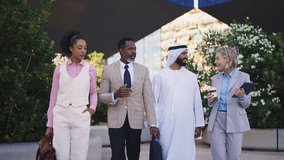 Group of multiethnic business people meeting an emirati businessman - International corporate business team bonding outdoors in the city - Powered by Shutterstock - Get 15% off with code: PIKWIZARD15