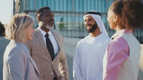 Group of multiethnic business people meeting an emirati businessman - International corporate business team bonding outdoors in the city - Powered by Shutterstock - Get 15% off with code: PIKWIZARD15