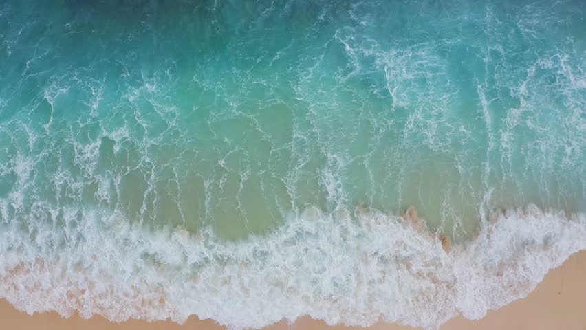 Stunning Aerial Bird's Eye View of Ocean Waves Washing Ashore in Bali, Indonesia, Asia. 4K Long Duration Static Shot