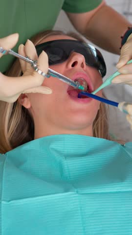 Female Professional Dentist Gives Anesthetic Injection for Dental Treatment and Toothache Relief. Concept of Modern Medicine and Health. Vertical Video. Slow Motion.