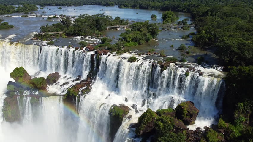 Top of Iguazu Falls in South America, wide angle panning aerial view of falls and surrounding jungle