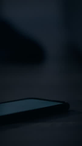 Close up of female hand reaching for phone to turn off alarm early morning at dusk. Early morning phone ringing hand looking for phone to turn off alarm. Sleepy girl lying on bed