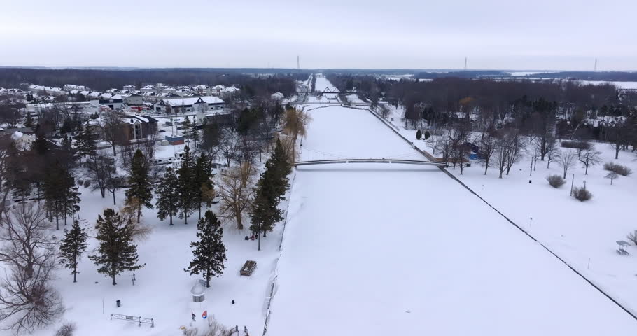 Aerial Winter View of a Pedestrian Suspension Bridge Over a Frozen Canal