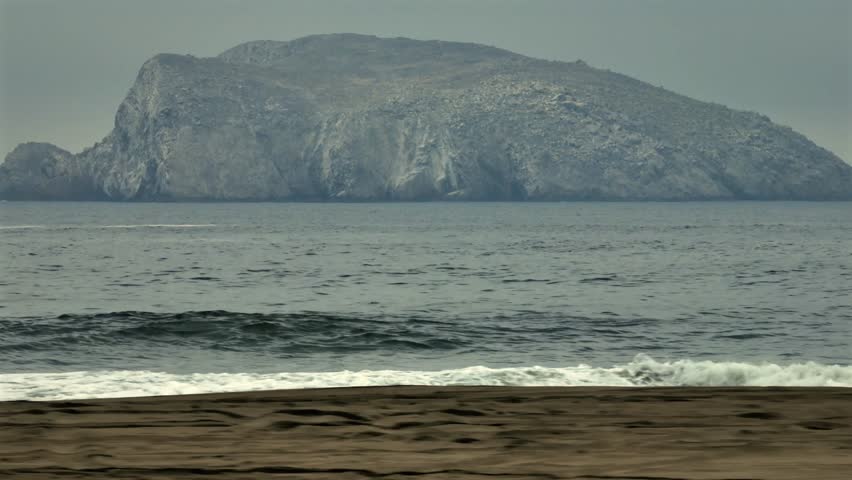 Straight on camera angled view of the famous La Peña Blanca rock and beach near Manzanillo, on a cloudy overcast day. Mexico, Colima state